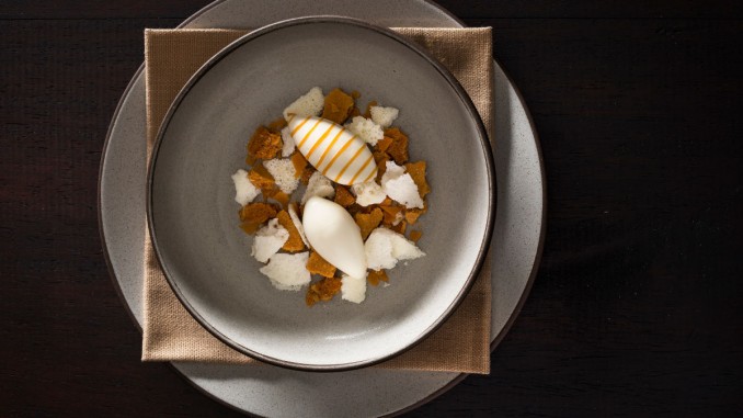 A dessert of honey oatmeal crumble with honey brittle, dehydrated milk foam, and ice milk drizzled with honey prepared by NoMad Executive Pastry Chef Mark Welker
